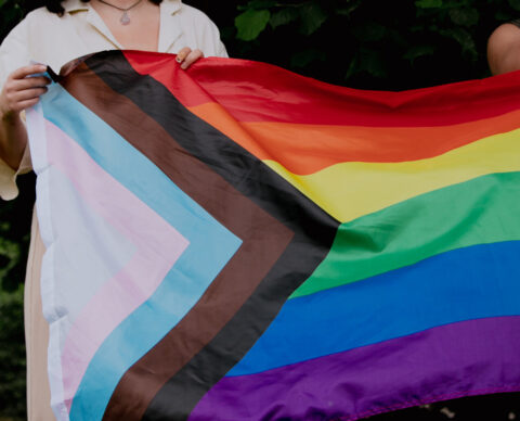 Photo of person holding the Progress Pride flag
